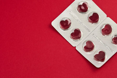 Red pills in the shape of a heart in a blister. Love pills. Creative concept.の写真素材