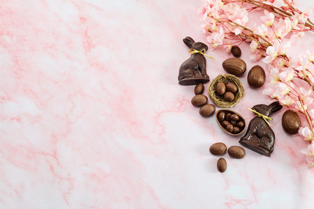Chocolate easter eggs and bunnies on pink marble background