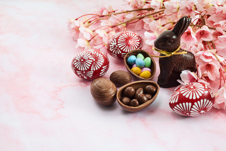 Chocolate easter eggs and bunnies on pink marble background