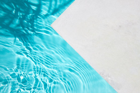 A serene image showcasing a clean pool with crystal blue water and a white poolside.の写真素材