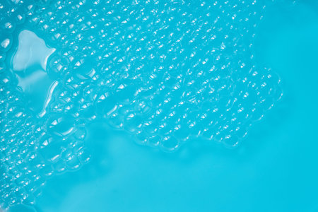 Blue Foam Surface. Clear bubbles floating on a bright turquoise surface