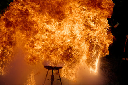 An intense fire explosion captured in detail, revealing the ferocity and motion of the flames. The image showcases vibrant shades of orange and yellow.の写真素材