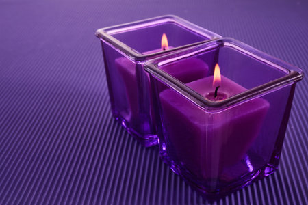 Purple Candle Glow. Two purple candles in glass holdersの写真素材