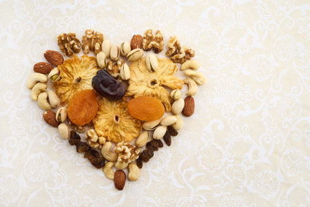 Concept of the Jewish holiday Tu Bishvat. Heart-shaped arrangement of dried fruits and nutsの写真素材
