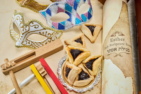 Purim Celebration Items. Festive Purim setup with Esther scrolls, Hamantaschen, and a maskの写真素材