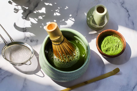 Traditional Matcha Preparation. Elegant matcha tea setup with a whisk, strainer, and green powderの写真素材