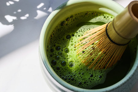 Matcha Whisking. Green matcha in a bowl with a bamboo whiskの写真素材
