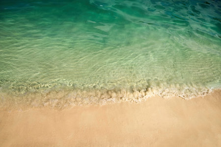 Serene Beach Shoreline. Clear turquoise water gently laps against a sandy beach.