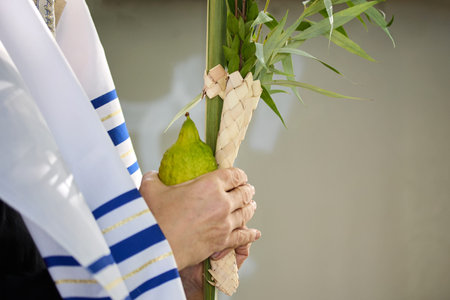 Succot. Jewish man in a Tallit praying while waving the Four Species, Lulav and Etrog