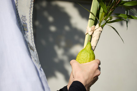 Succot. Jewish man in a Tallit praying while waving the Four Species, Lulav and Etrogの写真素材