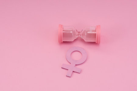 Hourglass with the female gender symbol. Womens health, menopause concept.の写真素材