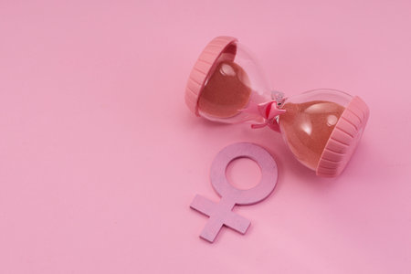Hourglass with the female gender symbol. Womens health, menopause concept.の写真素材