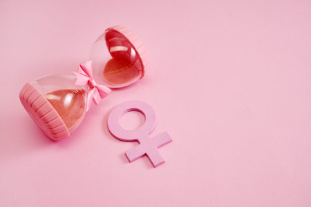 Hourglass with the female gender symbol. Womens health, menopause concept.