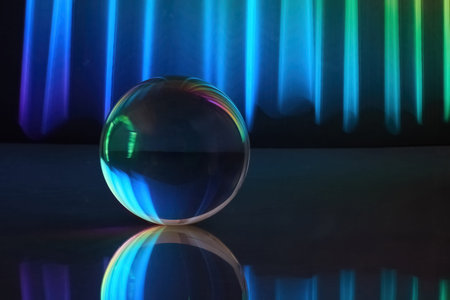 Colorful Light Sphere. Glass sphere reflecting vibrant neon lights in a dark, atmospheric setting.