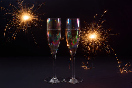 Sparkling Celebration. Two champagne glasses with bright sparklers against a dark background