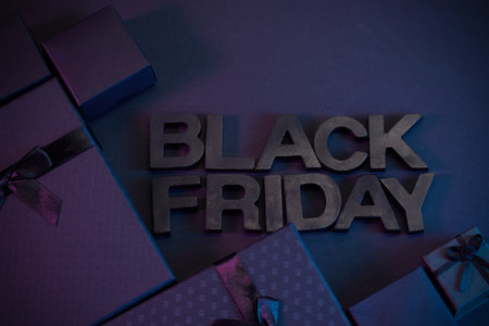 Black Friday Sale. Black Friday text surrounded by wrapped gifts with a moody dark blue and purple theme.の写真素材