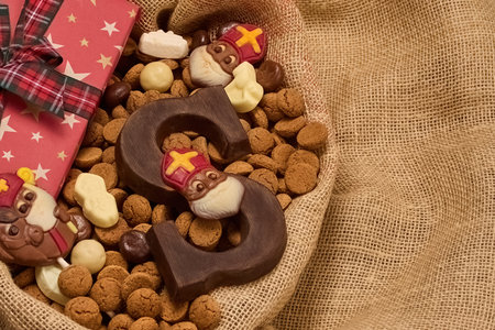 Festive Sinterklaas Display. A burlap basket with chocolate letters, Sinterklaas figures, and a starry gift boxの写真素材