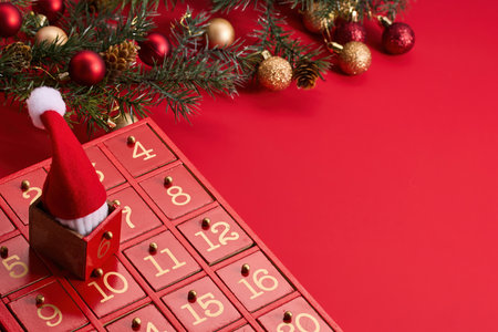 Festive Advent Calendar. Red advent calendar and Christmas decor on a vibrant red background.の写真素材