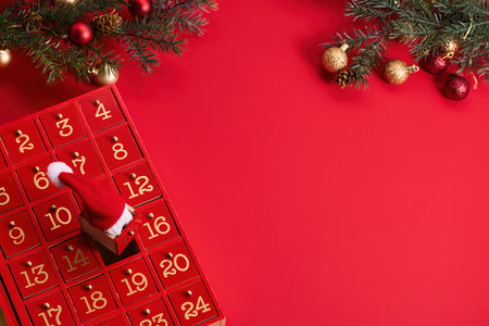 Festive Advent Calendar. Red advent calendar and Christmas decor on a vibrant red background.の写真素材
