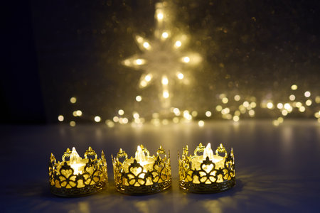 Candlelit Starry Night. Three ornate candles glow with a star-shaped light backdropの写真素材