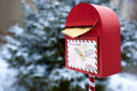 Festive Mailbox. A red mailbox with a letter to Santa in a snowy outdoor setting.