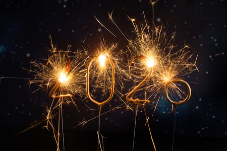Sparkling New Year 2026. Glowing sparklers forming the number 2026 against a starry night sky
