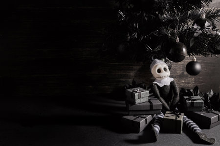 Gothmas. Dark Christmas Scene. A gothic style Christmas setting with a black tree, gifts, and a skeleton doll.の写真素材