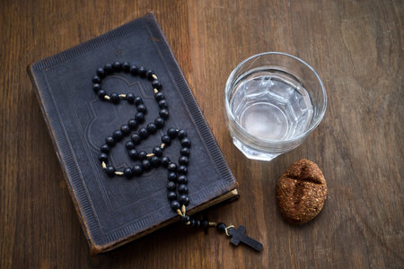 Bible, rosary, water, bread symbolizing lenten fasting and prayer