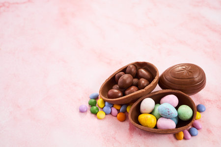 Easter chocolate egg candy spilling on pink background