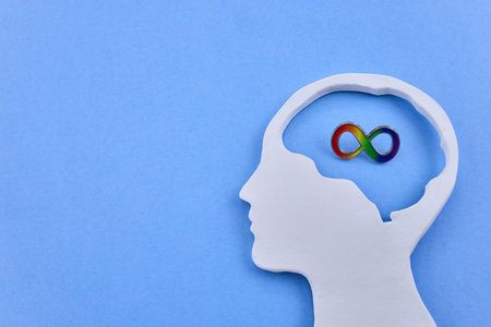 Human head silhouette with rainbow infinity symbol representing neurodiversity