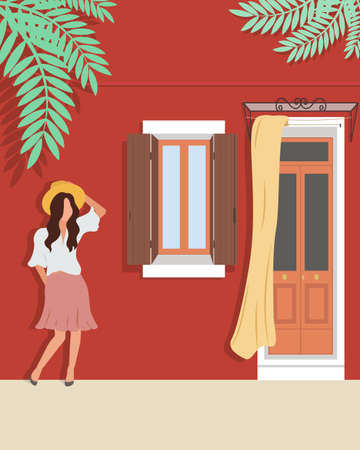 Woman in a hat stands against the wall of the house.のイラスト素材