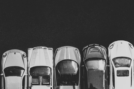 Back and white cars parked in a row on a black surfaceの写真素材
