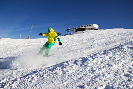 Small snowboarder on blue sky backdrop.の写真素材