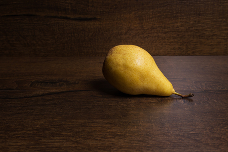 Yellow pear on a dark brown backgroundの写真素材