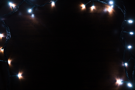 multicolored Christmas lights on a wooden backgroundの写真素材