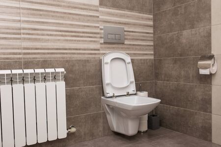 New white ceramic toilet on a gray tile background. The interior of the restroom.の写真素材