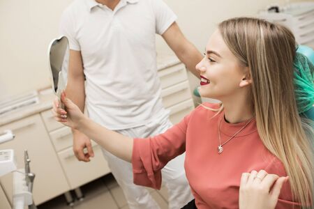 The girl is a blonde with a pleasant smile at the dentists appointment.の写真素材