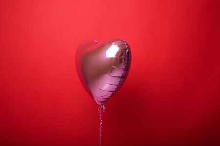 Balloon heart on a red isolated background.の写真素材