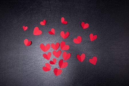 A lot of small hearts of red color against on a black background. Happy Valentine's Day.の写真素材
