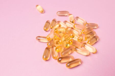 Close up vitamin C capsules on pink isolated background.の写真素材
