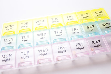 Organizer for medical pills on a white isolated background close-up. Organization of taking pills of...