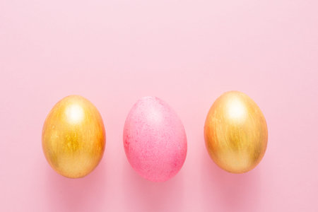 Multi-colored Easter eggs on a pink isolated background. Easter is a bright holiday.
