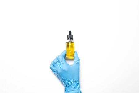 Male hand in a medical glove with a vaccine on a white background.の写真素材