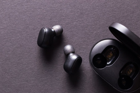 Black wireless headphones close-up on a black isolated background.