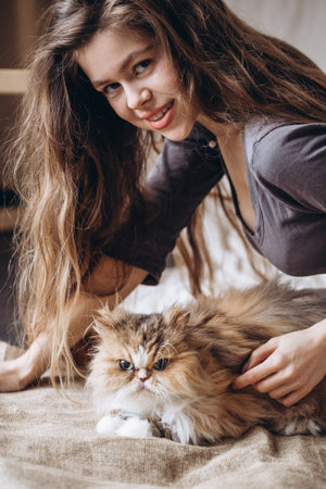 Girl communicates with her domestic red fluffy cat. Love for animals.