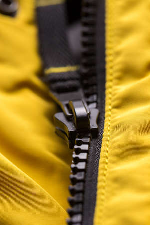 Zipper on clothes close-up. black color. Bright yellow jacketの写真素材