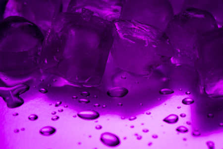 A pile of ice cubes in purple on a reflecting tableの写真素材