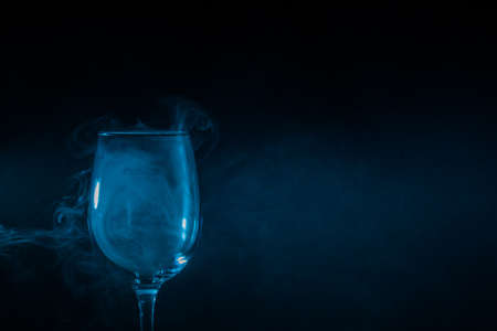 Wine glass filled with smoke on a black backgroundの写真素材