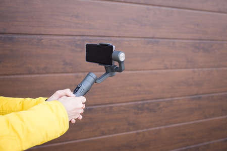 A man holds a stabilizer for smartphones. Mobile shooting on the street.の写真素材