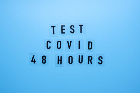 The word Covid test 48 hours on a blue background and a medical mask.の写真素材